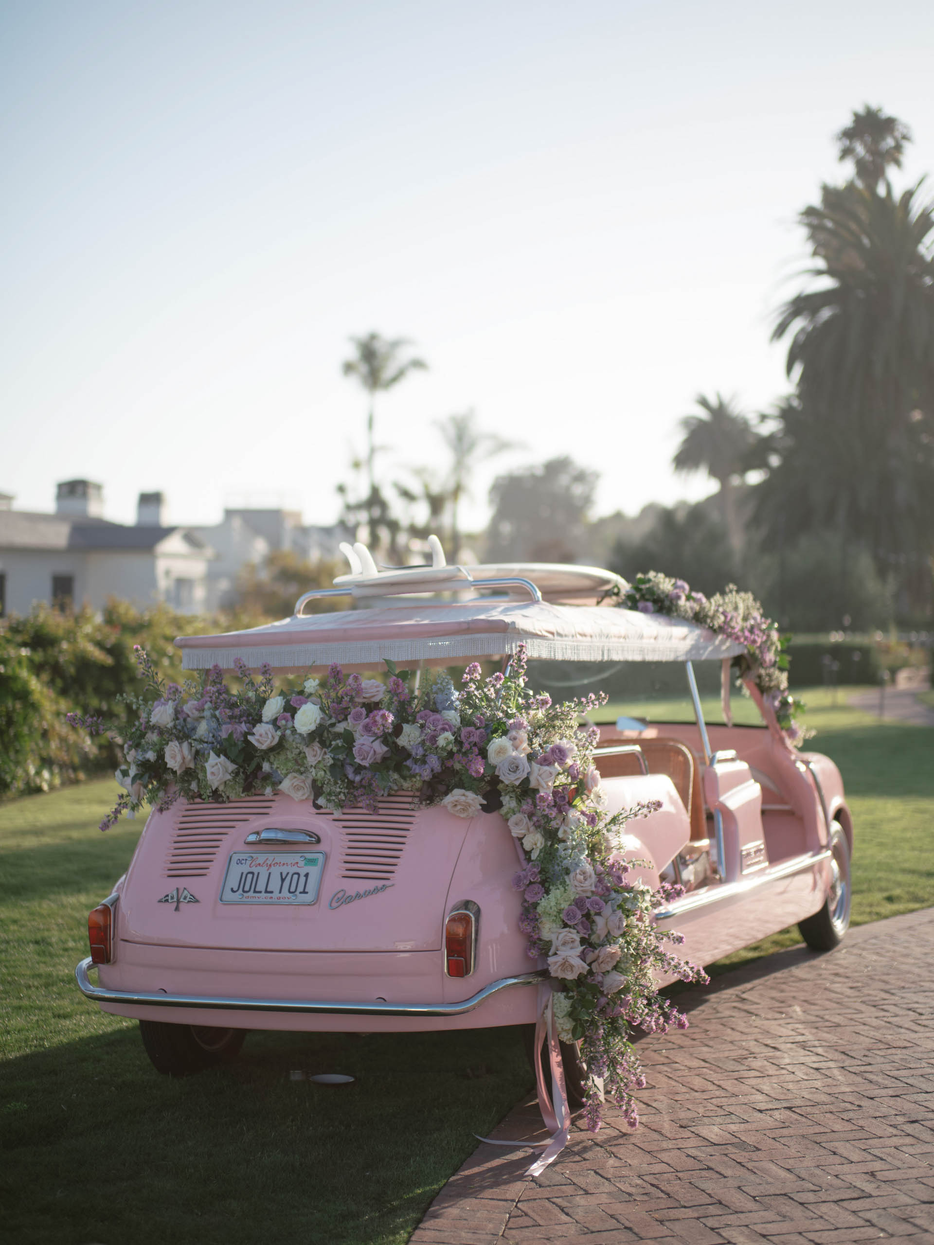 pink car outside decorated with flowers.